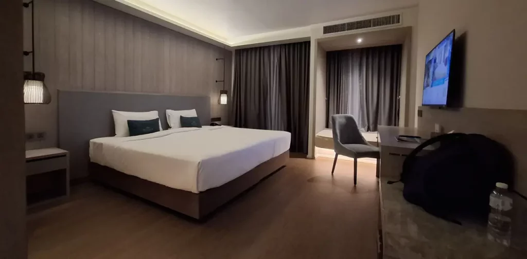 Ein Hotelzimmer mit einem Doppelbett in Brauntönen im Hotel Divalux, Bangkok.