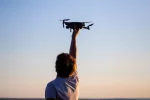 Ein Drohnenpilot hält eine DJI Mavic Air in die Höhe.